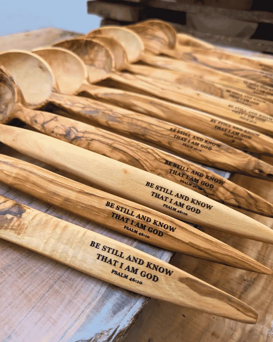 Rows of olive wood spoons engraved with Be still and know that I am God, Psalm 46:10