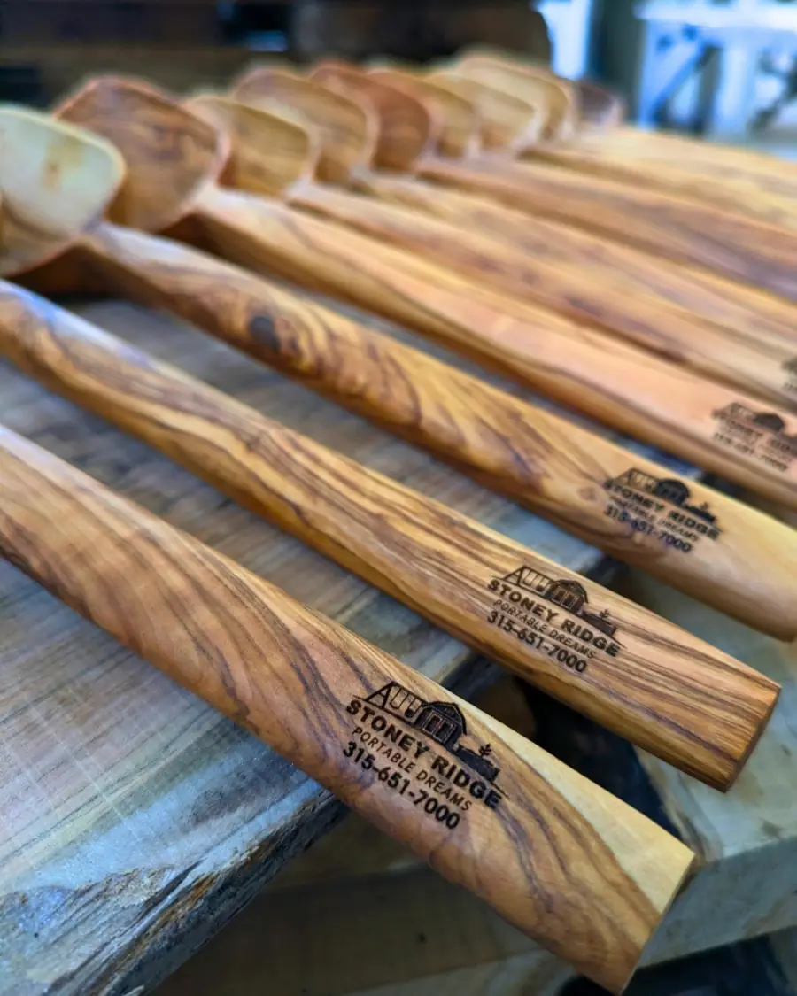 Row of olive wood cooking spoons laser-engraved with the Stoney Ridge Portable Dreams logo and phone number
