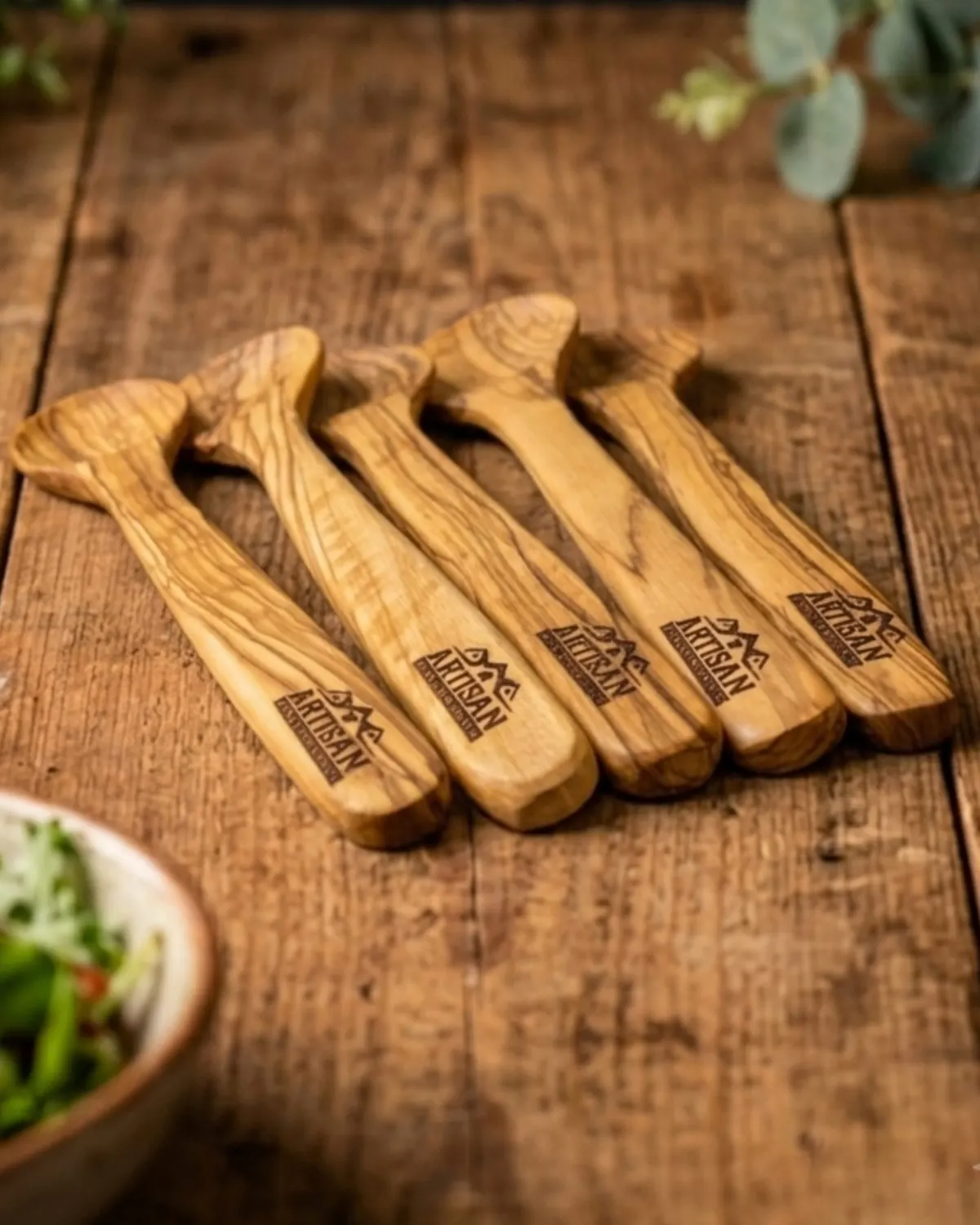 Set of olive wood salad servers laser-engraved with the Artisan logo on their handles