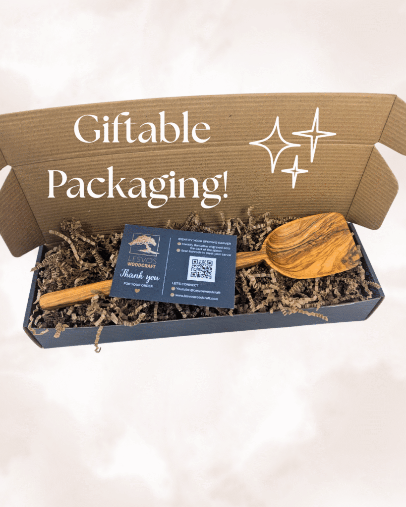 Close-up of olive wood utensils in gift packaging, with a small thank you card and care instructions visible."